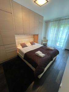 a bedroom with a large bed with two towels on it at Cappuccino by OneApartments in Jurata