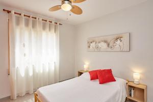 - une chambre blanche avec un lit et un ventilateur de plafond dans l'établissement La mejor vista al mar !!!, à Calafat
