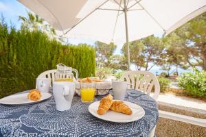 - une table avec deux assiettes de croissants et de jus d'orange dans l'établissement La mejor vista al mar !!!, à Calafat