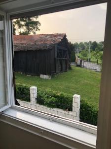 a window view of a yard with a building at Apartman Brzak in Zagreb