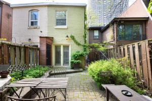 um pátio com mesas e cadeiras em frente a uma casa em The Downtown Victorian em Toronto