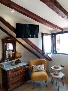 een woonkamer met een stoel en een tv bij Apartments & Rooms Trogir Stars FREE PARKING in Trogir