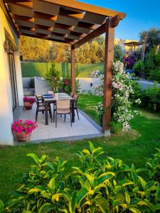 patio con tavolo e sedie sotto un pergolato in legno di Suelo Flat Villa for Family a Turgutreis