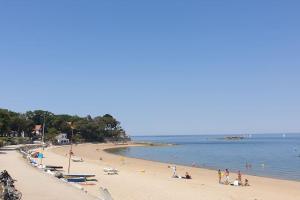 a group of people on a beach near the water at La Perséide - Maison neuve 900 m plage in Notre-Dame-de-Monts