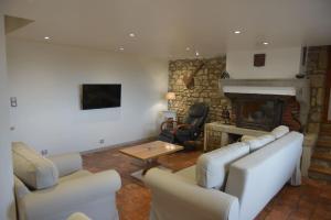 a living room with white furniture and a stone fireplace at Domaine-Bayard in Bergesserin