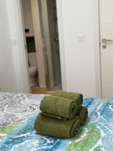 a pile of towels sitting on top of a bed at Alojamiento Aguacate in Madrid