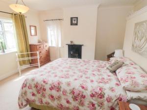 a bedroom with a bed with a floral bedspread at Sunnyside Cottage in Filey