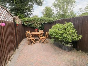 a patio with a table and chairs next to a fence at Sunnyside Cottage in Filey