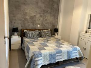 a bedroom with a bed with a checkered blanket at Angelo’s Elegant Summer House in Possidi