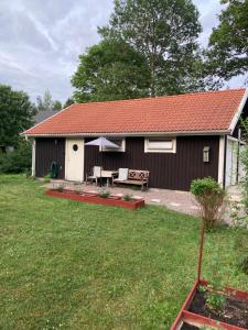 una casa con una mesa y una sombrilla en el patio en Fint boende i vackra Marielund, en Uppsala