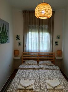 a bedroom with two beds and a chandelier at Studio apartman Cactus in Zagreb