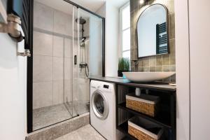 een badkamer met een wasmachine en een wastafel bij Park Promenada Brown Apartment in Warschau