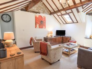 a living room with a couch and a table at Stablemans Cottage at Stepping Stones in Ambleside