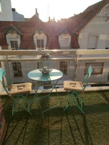 - Balcón con mesa verde y 2 sillas en Magnifique studio double cabine en Le Touquet-Paris-Plage