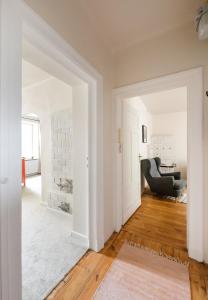 een open woonkamer met witte muren en houten vloeren bij Park Promenada Brown Apartment in Warschau