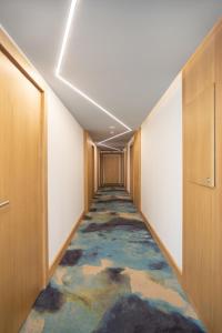 um corredor com um tapete colorido num edifício de escritórios em Morski Apartament em Sarbinowo