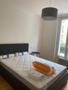 a bed with an orange object on top of it at Super appartement refait à neuf beaucoup de charme in Boulogne-Billancourt