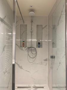 een douche in een badkamer met wit marmer bij Super appartement refait à neuf beaucoup de charme in Boulogne-Billancourt