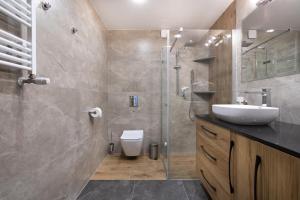 a bathroom with a sink and a toilet and a shower at Morski Apartament in Sarbinowo +22 photos