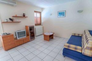 a living room with a bed and a tv at Arka in Stara Novalja