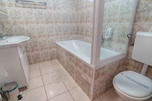 a bathroom with a tub and a toilet and a sink at Arka in Stara Novalja +50 photos
