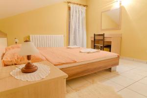 a bedroom with a bed and a table with a lamp at Arka in Stara Novalja