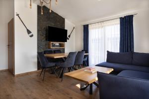 uma sala de estar com um sofá azul e uma mesa em Morski Apartament em Sarbinowo