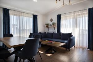 a living room with a blue couch and a table at Morski Apartament in Sarbinowo
