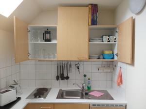 a kitchen with a sink and cabinets with utensils at Bed and Breakfast Wehlen in Stadt Wehlen