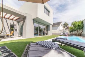 ein Hinterhof mit einem Swimmingpool und einem Haus in der Unterkunft Villa Kamila in Aroeira