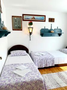 a bedroom with two beds and a shelf on the wall at Villa Urbana, Old Town Budva in Budva
