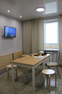 ウラジオストクにあるApartment on Chernyakhovskogo 5Vのテーブルと椅子、壁にテレビが備わる客室です。