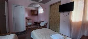 a bedroom with a bed and a tv on a wall at Guest House LIBU Zugdidi in Zugdidi