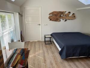 een slaapkamer met een bed en een houten vloer bij B&B Unieks in Nietap