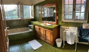 a green tiled bathroom with a sink and a tub at Les Pommiers, Bouilland in Bouilland +24 photos