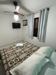 a bedroom with a bed and a ceiling fan at Pousada Saint Germain in Búzios