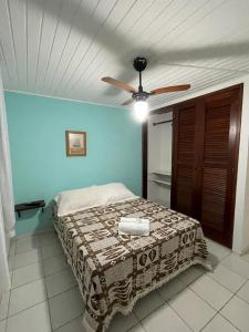 a bedroom with a bed with a ceiling fan at Pousada Saint Germain in Búzios