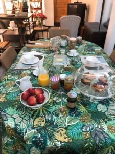 a table with plates of food and fruit on it at La Chambre de L'Embarcadère in Le Conquet