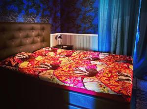 - une chambre avec un lit et une couette colorée dans l'établissement Suojelumetsän sylissä oleva talo lähellä vesistöjä, à Keuruu