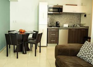 een woonkamer met een tafel en een keuken bij Lovely Apartment with Rooftop, Pool & Gym in CDMX in Mexico-Stad