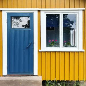 ケウルーにあるSuojelumetsän sylissä oleva talo lähellä vesistöjäの青いドアと窓が2つある家