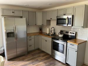a kitchen with white cabinets and a stainless steel refrigerator at Cape cottage inn in Cape May