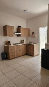 a kitchen with wooden cabinets and a tile floor at Departamento Frontera #4 en el Campestre in Ciudad Juárez