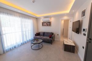 uma sala de estar com um sofá e uma televisão em Çalış Suites Hotel - Family only em Cesme