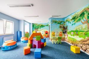a childrens room with a mural of a jungle at Atrium Oaza Sarbinowo in Sarbinowo