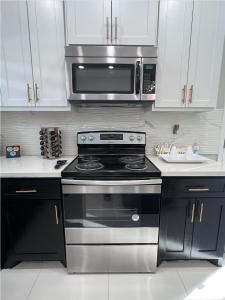 a kitchen with a stove and a microwave at Luxurious Modern Apartment #4 in Edinburg
