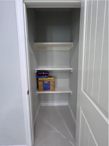 a walk in closet with white shelves and a door at Luxurious Modern Apartment #4 in Edinburg