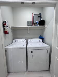 a laundry room with two white washers and a shelf at Luxurious Modern Apartment #4 in Edinburg