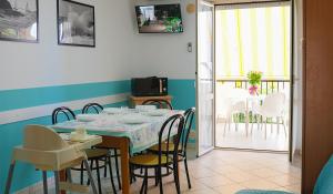 a dining room with a table and chairs and a balcony at Residence Riviera in Alba Adriatica
