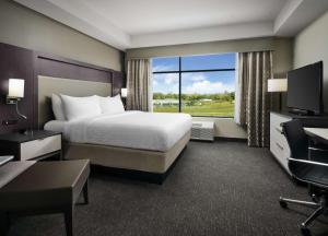 a hotel room with a bed and a large window at Best Western Plus Executive Residency Jackson Northeast in Jackson